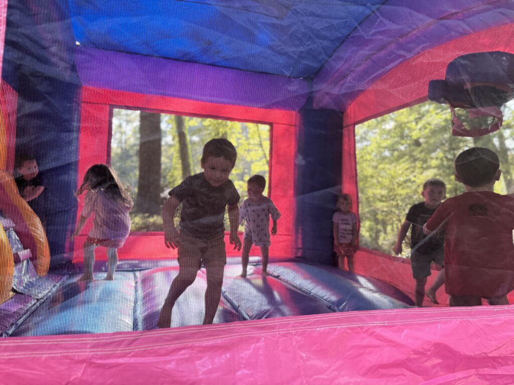 Kids jumping and playing inside a bounce house rental in College Park, GA provided by Marques Amusement Company