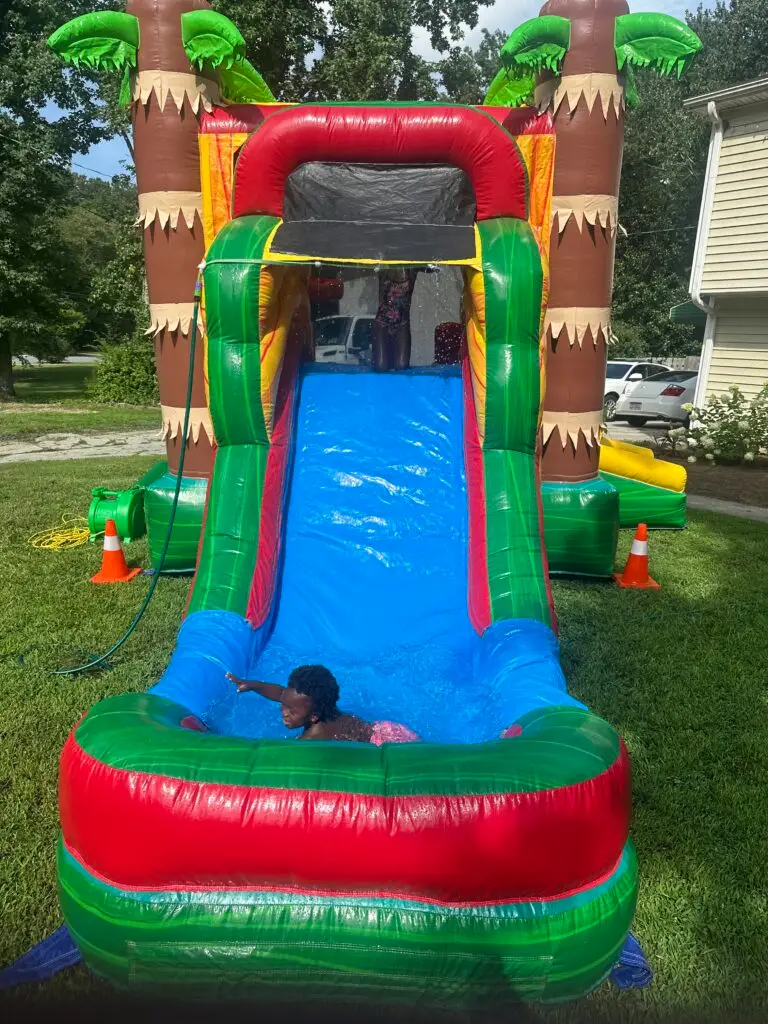 Kids enjoying a backyard water slide rental in College Park, GA provided by Marques Amusement Company