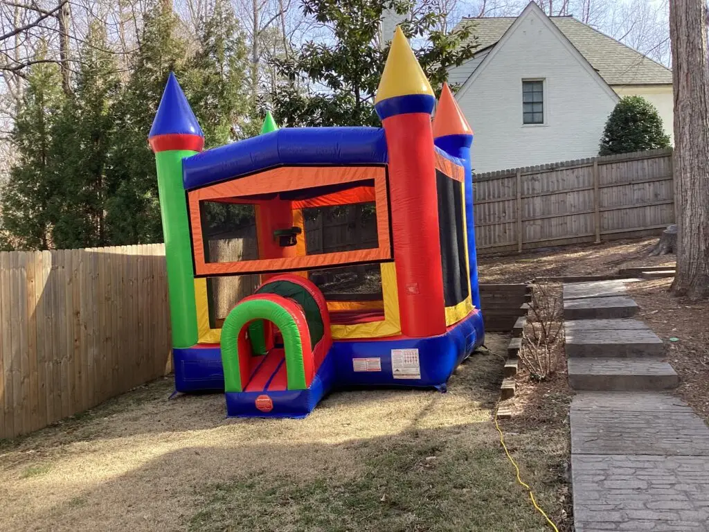 Bounce house rentals set up in a backyard in East Cobb, Georgia for a kids’ party by Marques Amusement Company