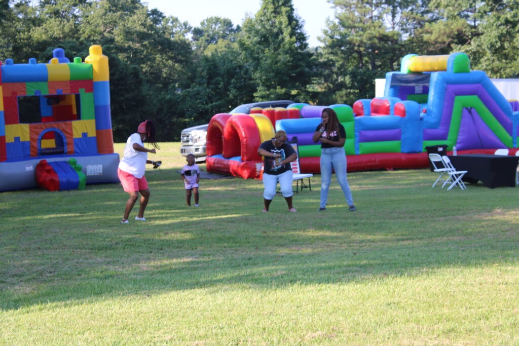 Families enjoying bounce house and inflatable rentals at a community event in East Point, GA
