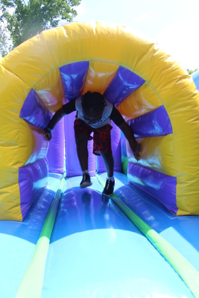 Child navigating an inflatable obstacle course at an outdoor event in Austell, Georgia