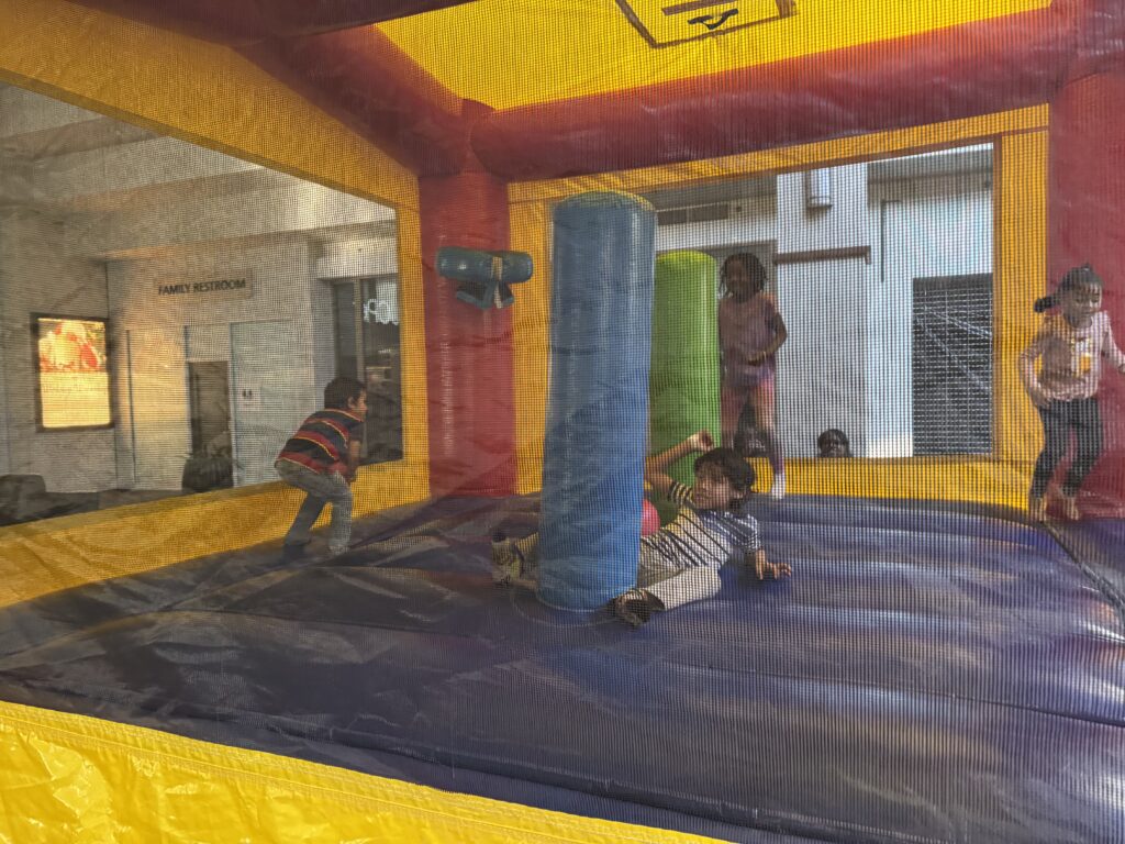 Kids enjoying bounce house rentals in Roswell, GA at an indoor family event with colorful inflatable fun