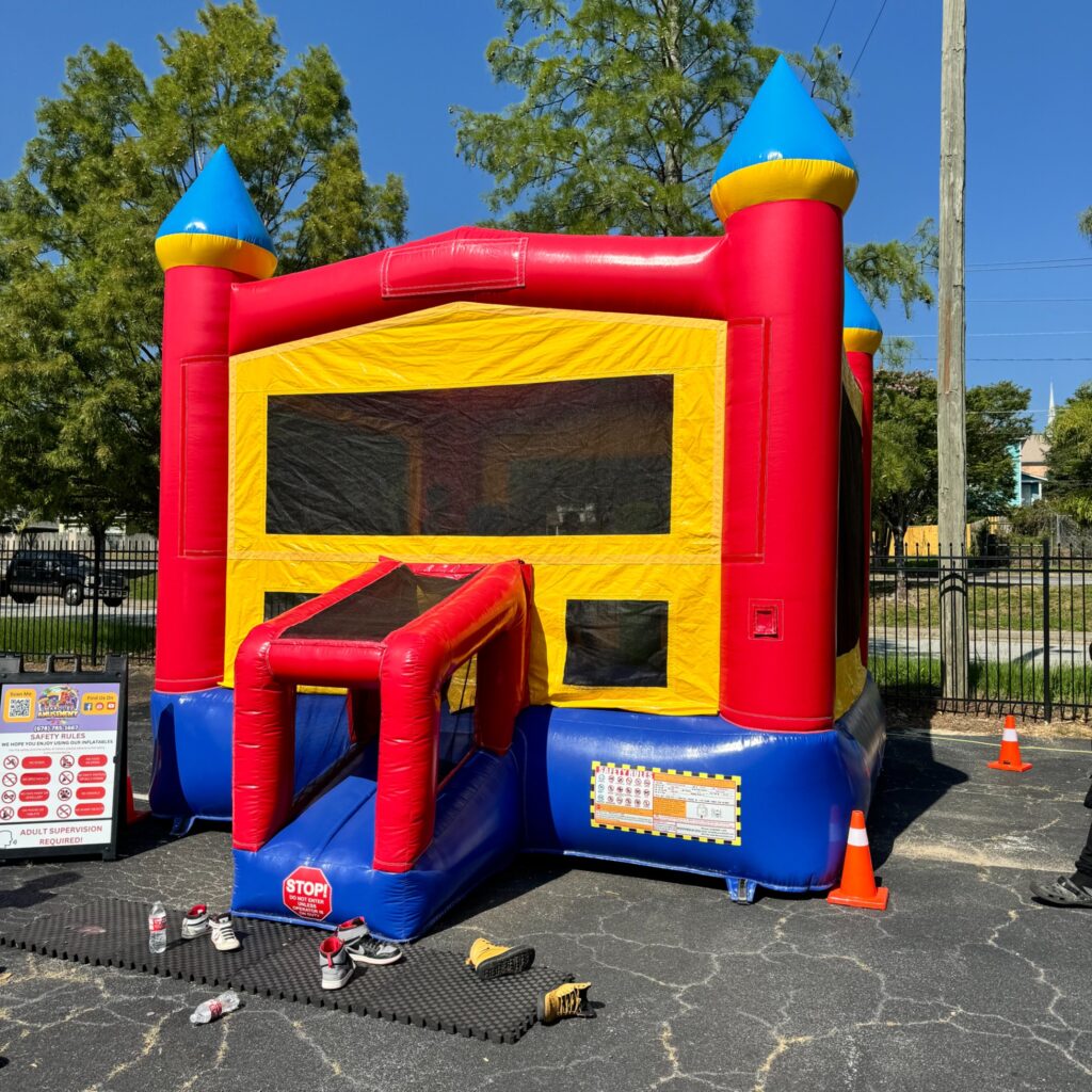 Red, blue, and yellow castle bounce house rental set up for a party in Sandy Springs, GA by Marques Amusement Company