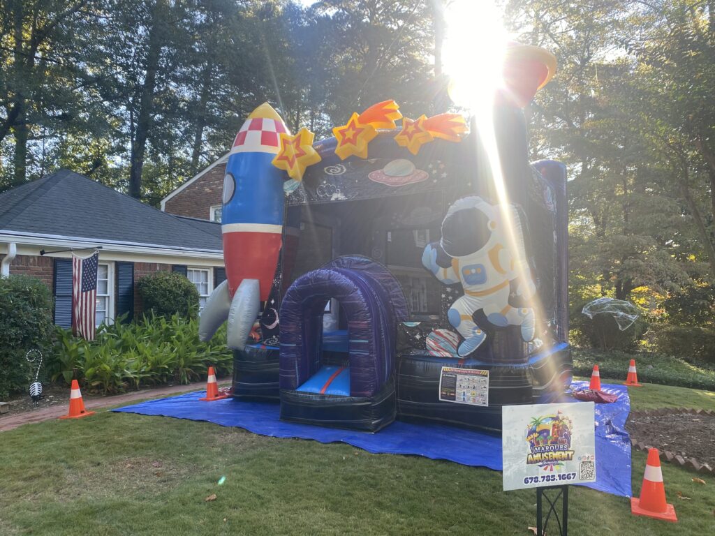 Space themed bounce house rental set up in a front yard in Sandy Springs, GA by Marques Amusement Company for a kids party