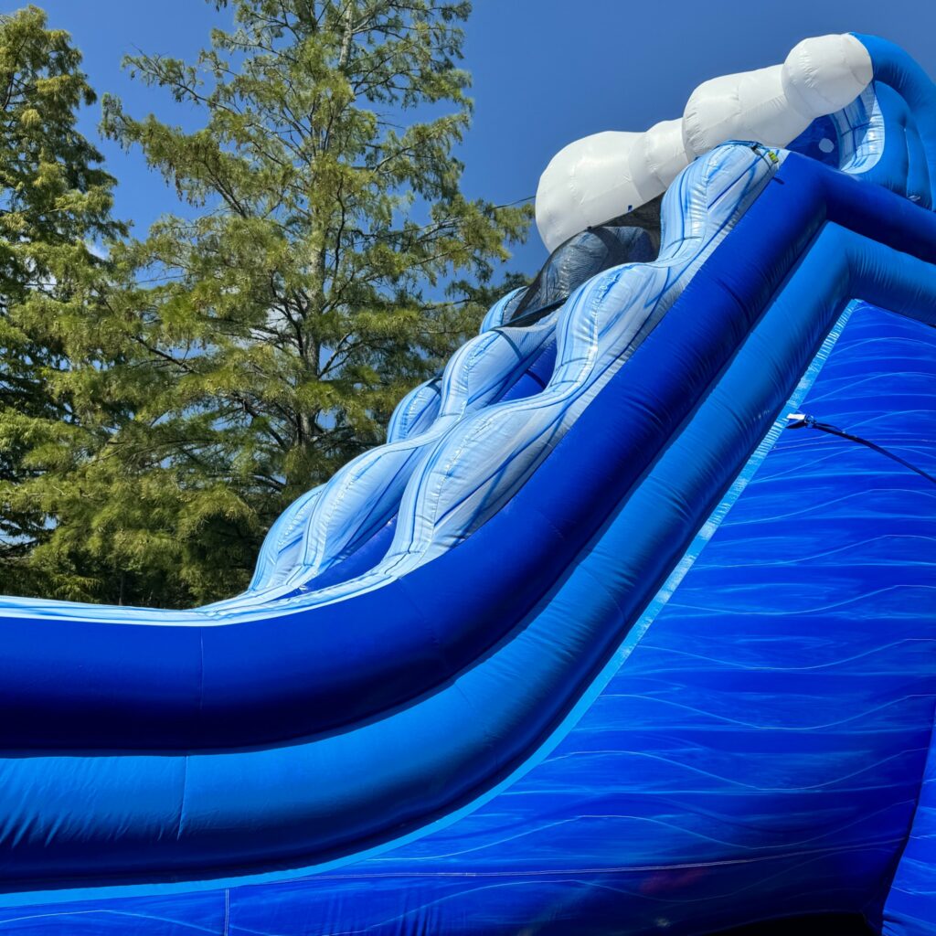 Large blue inflatable water slide rental set up in Sandy Springs, GA for a summer event by Marques Amusement Company