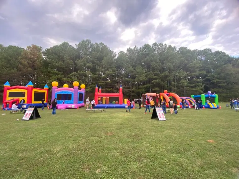 Bounce house safety at a supervised outdoor community event with multiple inflatables properly spaced and monitored