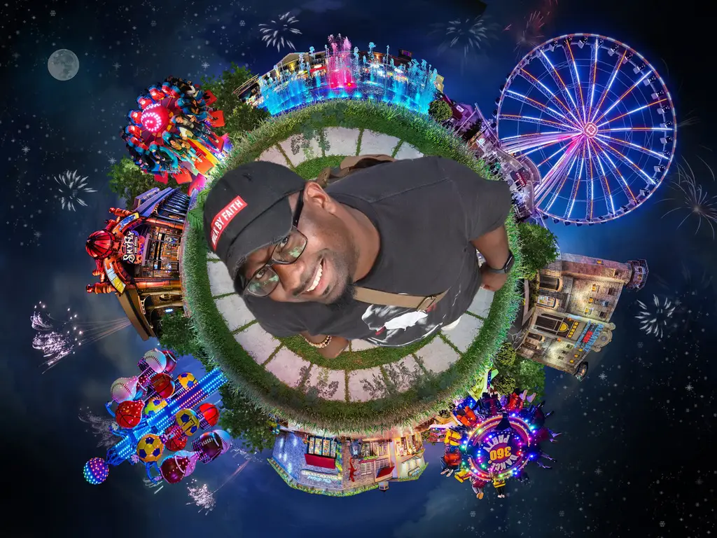 Latrelle Samuels founder of Marques Amusement Company Atlanta with carnival ride and amusement park backdrop